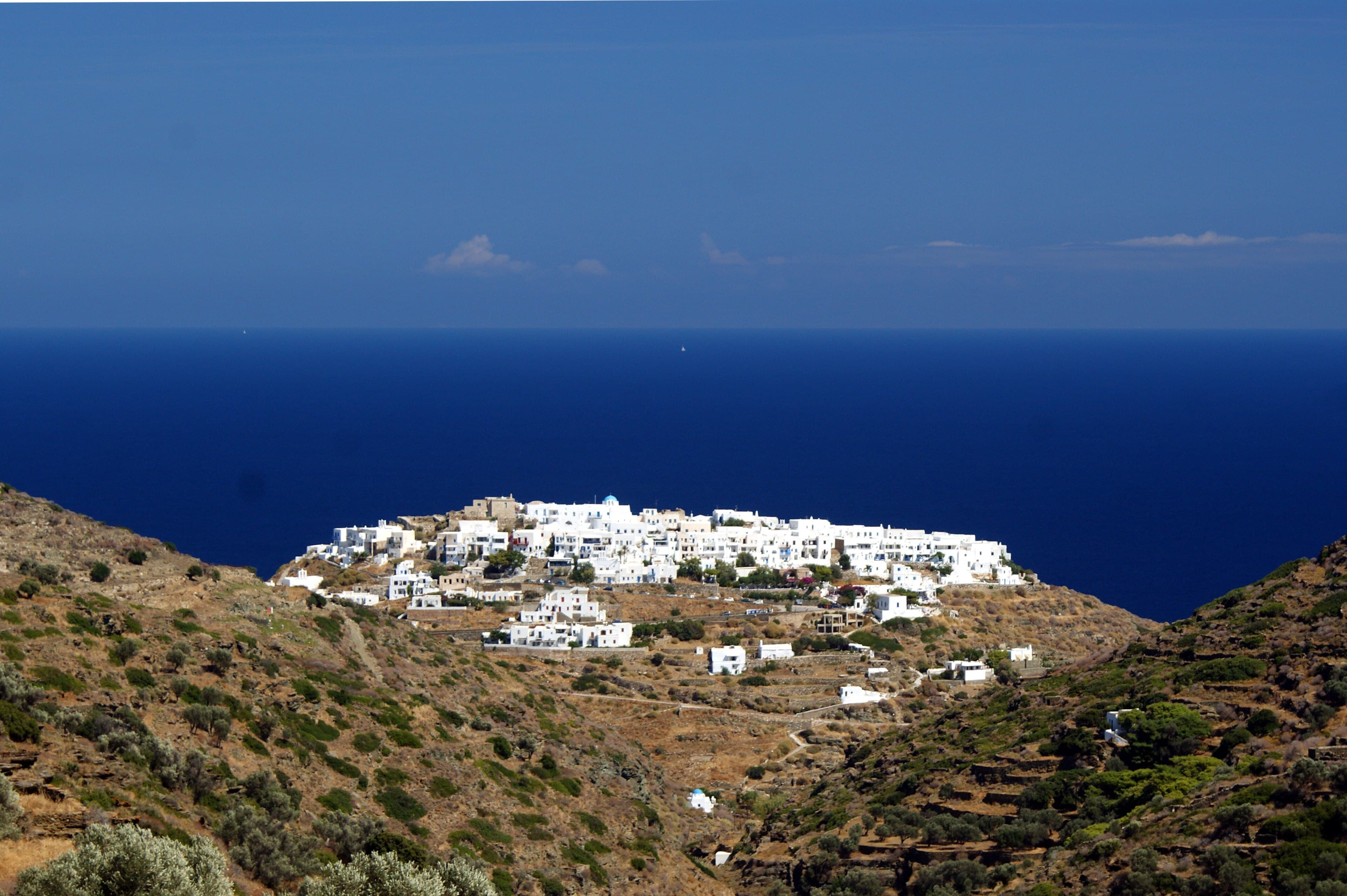 The village of Kástro on its headland, seen from the coast path above a deep blue sea.